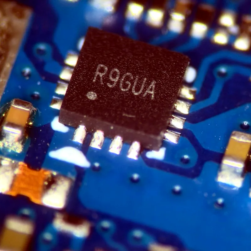 Close-up of a phone logic board chip during board-level microsoldering repair
